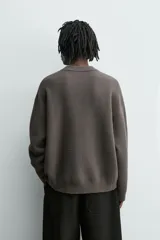Jersey de punto con textura efecto pelo, corte relajado, cuello redondo y manga larga con acabados en rib.