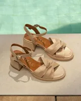 Sandalias de cuero color dorado, con plataforma y taco cuadrado. Presentan tiras cruzadas en el empeine y pulsera al tobillo con hebilla.