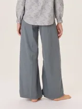 Pantalón ancho de algodón color verde oliva, con corte holgado desde la cadera hasta el tobillo. Presenta pinzas debajo de la rodilla, bordado de monograma en el bolsillo delantero y pespuntes a contratono.