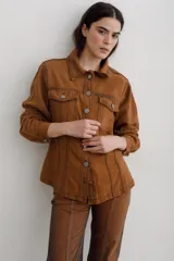 Chaqueta de denim color marrón, con corte entallado en la cintura, cierre frontal con botones metálicos y bolsillos superiores con solapa.
