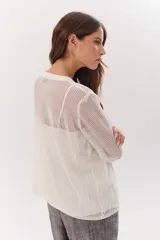 Sweater de tejido de punto calado color lila, con cuello en V y mangas largas.