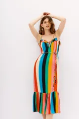 Vestido midi estampado con rayas verticales multicolor, tirantes finos ajustables y detalle de lazo en el escote. Presenta un corte holgado con un volante fruncido en el ruedo.