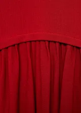 Vestido largo rojo de punto combinado, con cuello halter, sin mangas y diseño evasé con falda fluida y amplia.