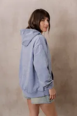 Canguro oversize fucsia con efecto washed, capucha con cordones ajustables al tono, bolsillo frontal tipo canguro y terminaciones de rib en puños y cintura.