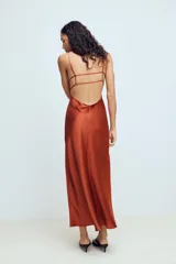 Vestido midi de tejido satinado color terracota, con escote en pico, tirantes finos ajustables y espalda con tiras cruzadas.