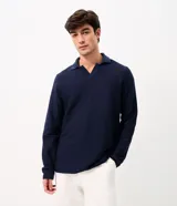 Remera de manga larga color marrón, confeccionada en tejido texturizado con cuello en V tipo polo. Presenta un diseño de calce confortable y acabado moderno.