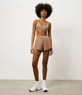 Short runner deportivo 2x1 de microfibra color bordó, con cintura elástica, bolsillo funcional con cierre y bajo redondeado.