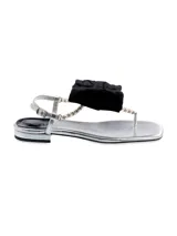 Sandalia plateada de tira con punta cuadrada y tacón bajo con detalle de perlas, lazo gigante negro y correa en el tobillo.