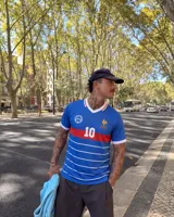 Remera de fútbol inspirada en la selección de Francia, de color azul con franjas horizontales blancas y una franja roja en el pecho, cuello en V blanco y dorsal 10 en la parte frontal.