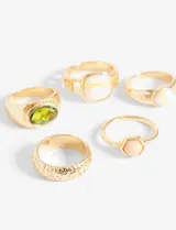 Set de anillos dorados con diferentes diseños, algunos con piedras de colores y otros con texturas.