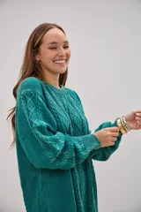 Sweater de tejido de punto con diseño de ochos y rombos en el frente, cuello redondo, mangas largas con puños ajustados y corte holgado.