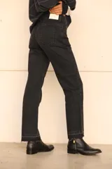 Pantalón de jean recto color negro con detalle desflecado en los tobillos.