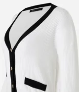 Cardigan de punto blanco con escote en V, botones metalizados, bolsillos falsos, cuello y vista contrastantes en negro, y bajo acanalado.