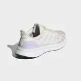 Championes de running Adidas Ultrarun 5, color crema con estampado sutil en rosado y detalles en lila. Cuentan con tres franjas blancas características de la marca y una suela gruesa blanca con base negra.