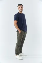 Pantalón cargo de hombre con fit slim, confeccionado en una mezcla de algodón y elastano. Presenta cierre de cremallera y botón, bolsillos laterales tipo cargo, pasa cinto y terminación con puños elásticos en los tobillos.