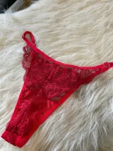 Conjunto de lencería compuesto por un bralette triangular de encaje con breteles regulables y una tanga de encaje regulable con corte media less.