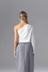 Top asimétrico color visón con una manga larga.