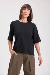 T-shirt negra de manga corta, cuello redondo y corte holgado.