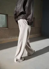 Pantalón de tiro medio con diseño recto y largo, con detalle de pinzas y estampado a cuadros. Cuenta con trabillas en la cintura, dos bolsillos laterales y cierre oculto de botón, gancho y cremallera.