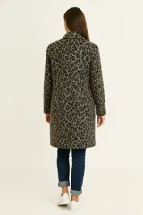 Tapado de corte recto y largo medio, confeccionado en tejido texturizado color gris. Presenta solapas clásicas, cierre frontal de un solo botón y mangas largas.