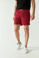 Short de baño liso con cintura elástica y cordón ajustable. Cuenta con dos bolsillos laterales, un bolsillo trasero y logo bordado. Confeccionado en tela ligera de secado rápido.