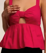 Blusa fucsia de tricolina de algodón con escote corazón, recorte cutout en el busto, volado en el bajo y cierre por cremallera en la espalda.