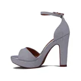 Sandalia de tacón alto y plataforma, color plateado con acabado brillante/glitter. Presenta una tira ancha en la parte delantera y una tira fina ajustable con hebilla en el tobillo.