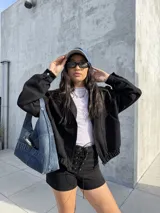 Campera tipo bomber de tela scuba con textura de gamuza, color negro, con cierre frontal, bolsillos laterales y puños elásticos.