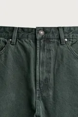 Pantalón barrel fit de mezclilla color verde militar, con efecto lavado, cinco bolsillos, cierre frontal con cremallera y botón, y detalle de pinzas en las rodillas.