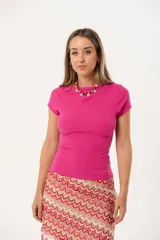 Remera fucsia de morley suave y elastizado, con calce al cuerpo, cuello redondo y detalle de pez bordado en el frente.