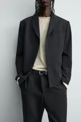 Blazer de corte relajado confeccionada en tejido con mezcla de lana. Presenta cuello con solapas de muesca, cierre frontal de tres botones, bolsillos con solapa en la cadera y un bolsillo en el pecho. Cuenta con manga larga con puños abotonados y aberturas en la espalda.