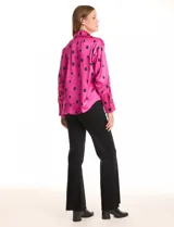 Camisa de satén con estampado de rectángulos negros sobre fondo blanco. Presenta cuello clásico con solapa, cierre frontal con botones metálicos y mangas largas con puños rectos.