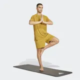 Remera deportiva Adidas de manga corta y cuello redondo, color mostaza/amarillo ocre, con un pequeño logo Adidas en relieve en el pecho. Presenta costuras reforzadas en los hombros.