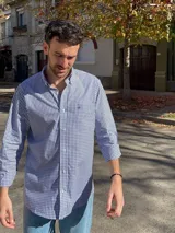 Camisa de hombre de algodón con estampado a cuadros en tonos rosado y celeste, corte clásico, manga larga, bolsillo en el pecho y botón en el cuello.