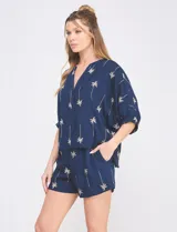 Short azul marino de tiro alto con bordado tropical de palmeras en tono beige, bolsillos laterales y cintura elastizada.
