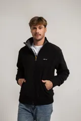 Campera de polar con cierre frontal, cuello alto tejido y puños y ruedo acanalados. Cuenta con un pequeño parche circular en la manga.