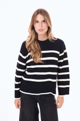 Buzo tejido de punto con diseño a rayas horizontales en blanco y negro, cuello redondo y mangas anchas.