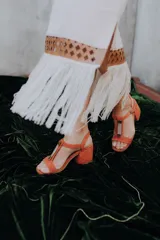 Pollera midi negra con detalle de cuero calado y flecos blancos en el ruedo.