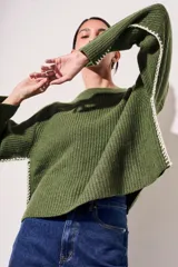 Sweater de lana color rojo, con cuello redondo, mangas largas y detalle de costura decorativa en los laterales.