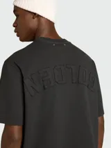 Remera de algodón color salmón, de corte holgado y cuello redondo con detalle de desgaste en el borde.