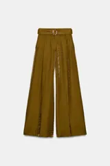 Pantalón de tiro alto color verde oliva, de pierna ancha y tejido satinado con textura arrugada. Incluye un cinturón del mismo tejido con hebilla decorativa.