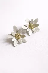 Par de aros con forma de flor, con pétalos plateados y centro dorado texturizado.