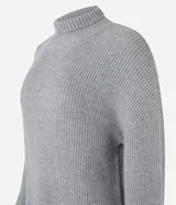 Suéter alargado de punto color rojo, con cuello alto ajustado y mangas largas ajustadas.