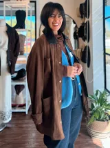 Campera de ecocuero color chocolate, con corte amplio y relajado. Presenta cuello camisero, cierre frontal con botones metálicos y bolsillos frontales de gran tamaño.
