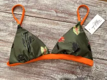Top de bikini verde con estampado de cactus y hojas, con breteles y contorno inferior naranja.
