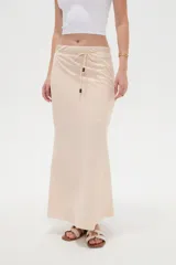 Falda larga color beige de modal, con cintura ajustable mediante cordón con detalles de cuentas en las puntas.