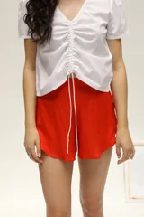 Short holgado color rojo, de fibrana con elástico en la parte trasera de la cintura y bolsillos laterales.