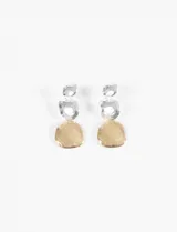 Caravanas largas de diseño colgante, compuestas por tres piezas circulares de formas orgánicas y texturizadas dispuestas verticalmente, combinando tonos plateados y dorados.