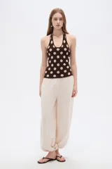 Top de punto al cuerpo con cuello halter, color beige con estampado de lunares marrones.
