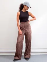 Pantalón wide leg de tiro alto con estampado animal print en tonos marrones. Presenta pretina ancha, cierre frontal con broche y bolsillos laterales aplicados.